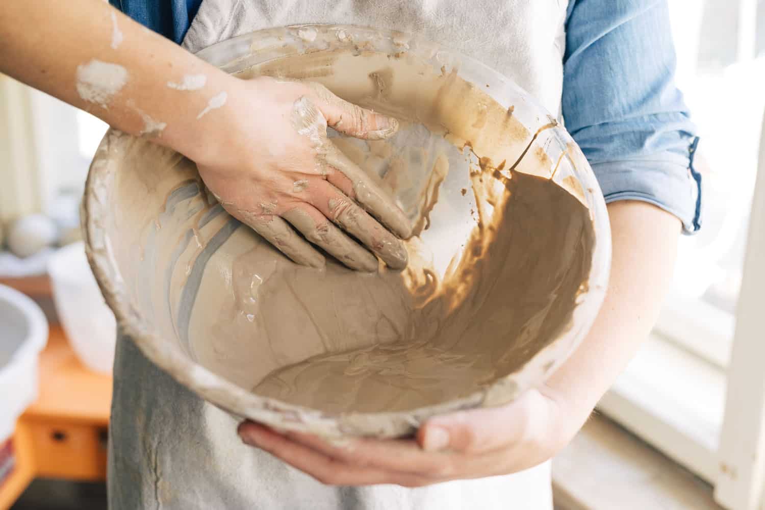 Woman making a clay mixture for her project