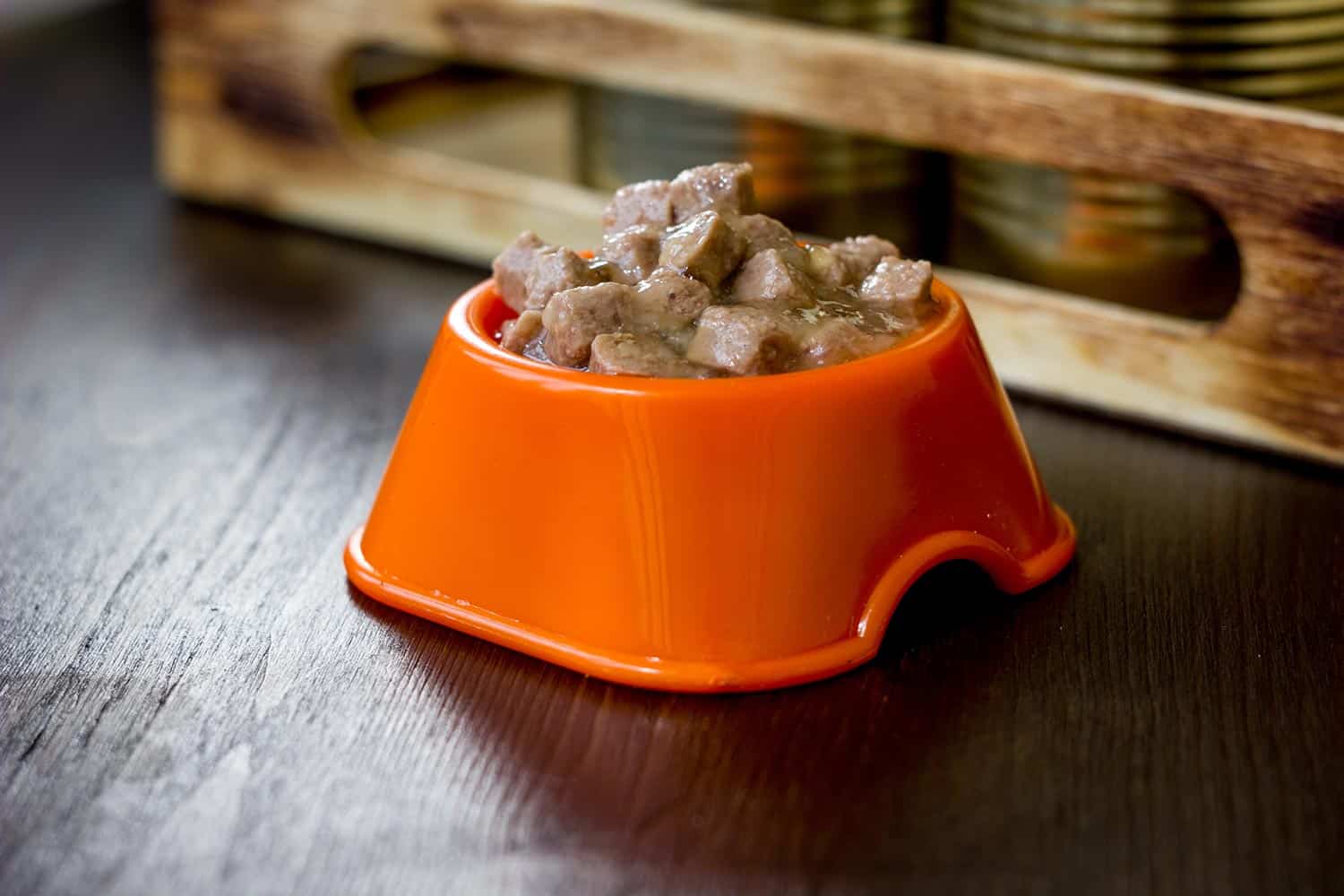 Canned pet food in a orange plastic bowl