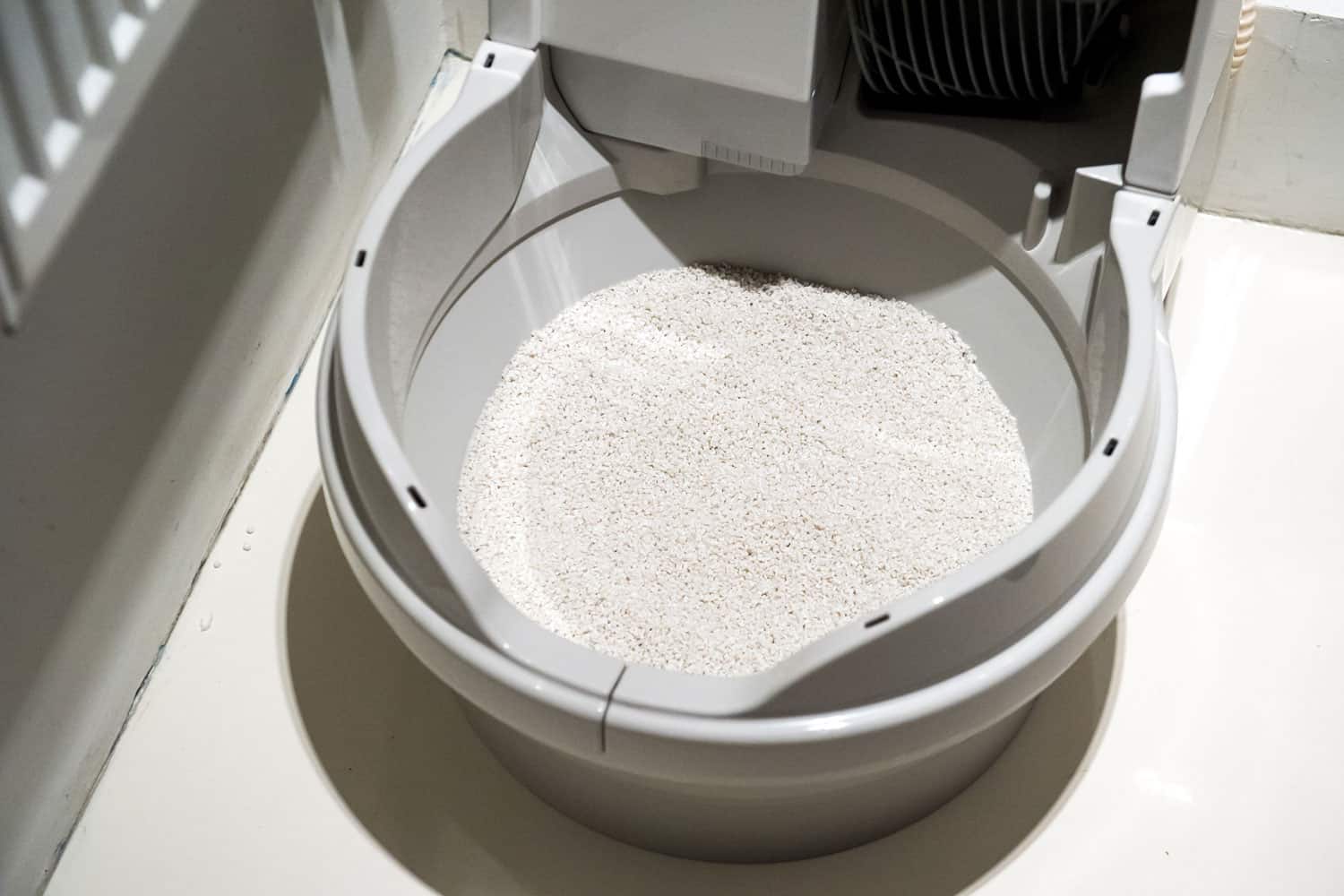 Newly cleaned litter tray of automatic cat litter box litter-robot showing yellow light
